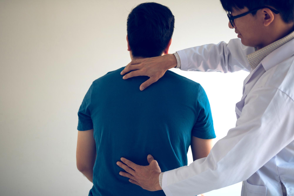 A doctor helping someone with lower back pain.